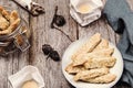 Homemade oatmeal cookies and candles in trendy organic candlesticks on grey vintage wooden table