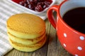 Homemade oatmeal cookies, cup of coffee or tea, and jam in saucer on napkin on wooden table. Use to display traditional quick and