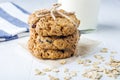 Homemade oatmeal cookies with raisins and chocolate and glass of milk on white table. Healthy snack for kids before bedtime or