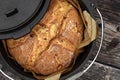 Homemade onion bread baked in a traditional Dutch oven on a rustic wooden background, top view of a freshly baked loaf Royalty Free Stock Photo