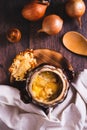 Homemade onion soup with cheese croutons in a pot on the table top and vertical view Royalty Free Stock Photo