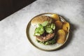 Homemade open beef burger with vegetables on a light concrete background