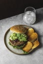 Homemade open beef burger with vegetables on a light concrete background