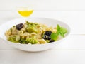 Homemade orecchiette pasta with broccoli, sun-dried tomatoes and herbs on a white wooden table. Italian dish, vegan, vegetarian Royalty Free Stock Photo