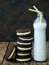 Homemade Oreo chocolate cookies with white marshmallow cream and botle of milk on dark background. Royalty Free Stock Photo