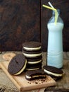 Homemade Oreo chocolate cookies with white marshmallow cream and botle of milk on dark background. Royalty Free Stock Photo