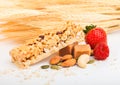 Homemade organic granola cereal bar with nuts and dried fruit on white background with oats and raw wheat. Strawberry and raspberr Royalty Free Stock Photo