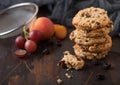 Homemade organic oatmeal cookies with raisins and apricots on dark wooden background with apricot and grapes. Kitchen flour mesh Royalty Free Stock Photo