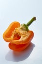 Half a yellow pepper with seeds on a gray background