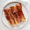 Homemade Oven Baked Bacon on a  Plate, top view. Flat lay, overhead, from above Royalty Free Stock Photo