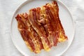 Homemade Oven Baked Bacon on a  Plate, top view. Flat lay, overhead, from above. Close-up Royalty Free Stock Photo