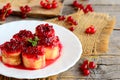 Homemade pancake sushi rolls with redcurrant jam on a white plate and a vintage wooden table. Stuffed pancakes dessert recipe