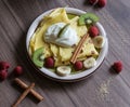 Homemade pancake with vanilla curd, raspberries, kiwi and banana pieces sprinkled with cocoa Royalty Free Stock Photo