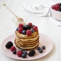 Homemade pancakes with berries and honey, side view. Closeup Royalty Free Stock Photo