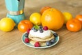 Homemade pancakes with colorful fruit around on wooden table