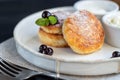 Homemade pancakes with cottage cheese on a dark lantern with black currants and cranberries. Breakfast for the whole family. Royalty Free Stock Photo