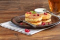 Homemade pancakes with cottage cheese on a wooden lantern with black currants and cranberries. Breakfast for the whole family. Royalty Free Stock Photo