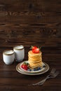 Homemade pancakes with fresh blueberries, strawberries and two caps of milk Royalty Free Stock Photo