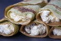 Homemade pancakes with green spirulina stuffed white cottage cheese with raisins on a black slate background, close up Royalty Free Stock Photo