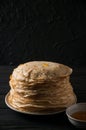 Homemade pancakes with honey and walnuts, vintage white plate, dipper, dark wooden table.