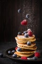 Homemade pancakes stack with sugar, strawberries and blueberries