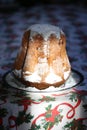 Homemade panettone closeup on beautiful christmas tablecloth. Sweet bread served as dessert on table