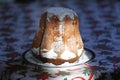 Homemade panettone closeup on beautiful christmas tablecloth. Sweet bread served as dessert on table