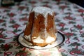 Homemade panettone closeup on beautiful christmas tablecloth. Sweet bread served as dessert on table