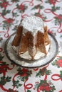 Homemade panettone closeup on beautiful christmas tablecloth. Sweet bread served as dessert on table