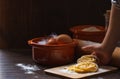 Homemade pasta on a Board with flour and a child`s hand holding pasta on a dark wooden background