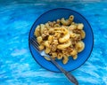Homemade pasta breakfast with minced chicken fried with spices and tomato sauce on a ceramic blue plate, served on a blue wooden Royalty Free Stock Photo