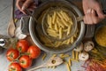 Homemade pasta cooking in a pot of water and cooking ingredients with a cutting board, top view. The concept of Italian cuisine an Royalty Free Stock Photo