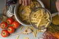 Homemade pasta cooking in a pot of water and cooking ingredients with a cutting board, top view. The concept of Italian cuisine an Royalty Free Stock Photo