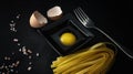 Homemade pasta tagliatelle fresh egg and eggshell on black background Royalty Free Stock Photo