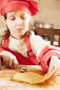 Homemade pastry. Cute little child girl chef cooking cakes dough on wooden desk with flour