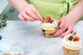 Homemade pastry. Woman cooking cakes. Tasty birthday cupcake on table. Confectioner decorate cupcakes with cream cheese and