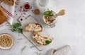 Homemade pate, spread or mousse in glass jar with sliced bread and herbs with pine nuts, light concrete background. Royalty Free Stock Photo