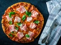 Homemade Pepperoni Pizza with fresh bacon over black background Royalty Free Stock Photo