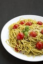 Homemade Pesto Pasta with Tomatoes and Pine Nuts on a black background, side view. Copy space Royalty Free Stock Photo