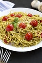 Homemade Pesto Pasta with Tomatoes and Pine Nuts on a black surface, side view Royalty Free Stock Photo