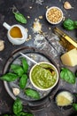 Homemade pesto sauce and ingredients, Traditional Italian pesto recipe for pasta on a dark background, vertical image. top view.