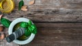 Homemade pesto sauce, prepared in a marble mortar. Ingredients for pesto, nuts, olive oil on a wooden table, selective focus on Royalty Free Stock Photo
