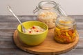 Homemade sauerkraut in two jars with a salad bowl and a fork on a wooden board. Rustic style Royalty Free Stock Photo