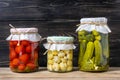 Homemade pickled cherry tomatoes, cucumbers, champignons, garlic, eggplant, red peppers in jars on wooden shelf Homemade canned Royalty Free Stock Photo