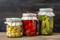 Homemade pickled cherry tomatoes, cucumbers, champignons, garlic, eggplant, red peppers in jars on wooden shelf Homemade canned Royalty Free Stock Photo