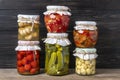 Homemade pickled cherry tomatoes, cucumbers, champignons, garlic, eggplant, red peppers in jars on wooden shelf Homemade canned Royalty Free Stock Photo