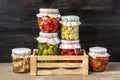 Homemade pickled cherry tomatoes, cucumbers, champignons, garlic, eggplant, red peppers in jars on wooden shelf Homemade canned Royalty Free Stock Photo