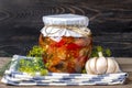 Homemade pickled cherry tomatoes, garlic, eggplant, red peppers in jars on wooden shelf Homemade canned and fermented foods Royalty Free Stock Photo
