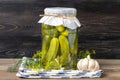 Homemade pickled cucumbers, garlic in jars on wooden shelf Homemade canned and fermented foods concept Seasonal product Royalty Free Stock Photo