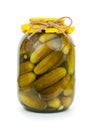 Homemade pickled cucumbers in glass jar with yellow paper wrapper. Jar of canned cucumbers isolated on white background, Close-up Royalty Free Stock Photo